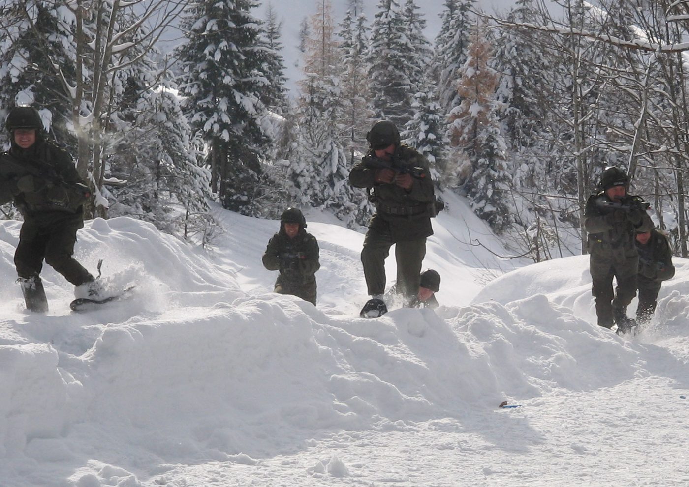 Soldaten bewegen sich im Tiefschnee durch verschneiten Bergwald